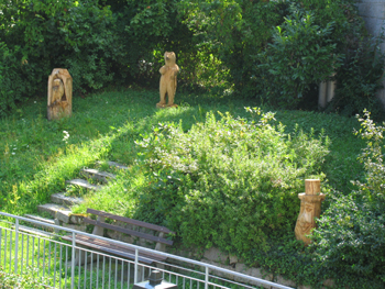Die Holzskulpturen auf dem Dorfplatz in Au