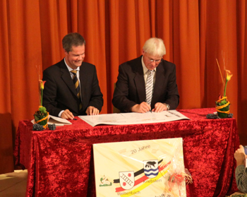 Die Partnerschaftsurkunde wird von Toni Huber und Christoph Merker unterzeichnet